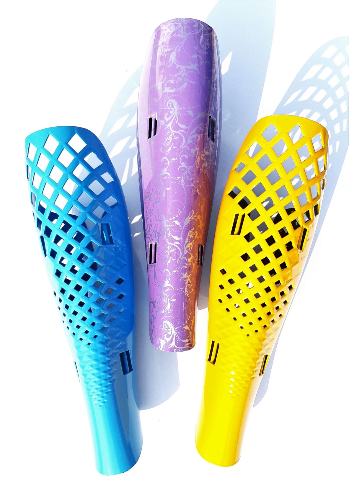 Trio of prosthetic leg covers in turquoise, lilac and yellow